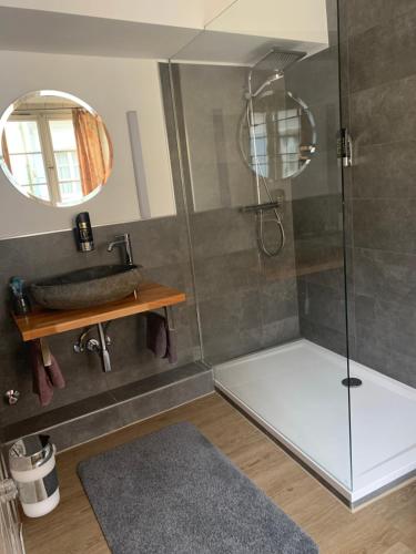 uma casa de banho com um chuveiro, um lavatório e um espelho. em Hotel zur Post em Blieskastel