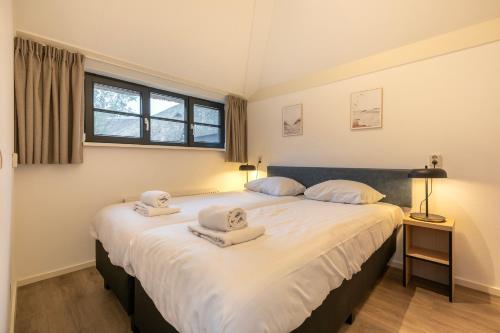 1 dormitorio con 2 camas y toallas. en Dormio Park Scorleduyn, en Schoorl