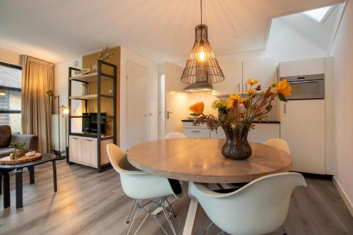 a kitchen and dining room with a table and chairs at Dormio Park Scorleduyn in Schoorl