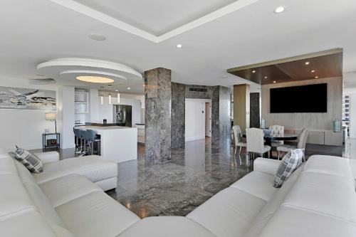 a living room with white couches and a kitchen at LUXURY PENTHOUSE ON THE BEACH 3/3 OCEANFRONT CONDO in Hollywood