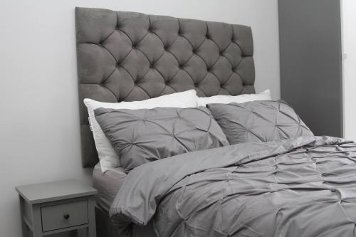 a bedroom with a large bed with a padded headboard at New Cosy Studio in London! in London