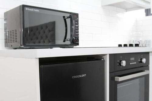 a microwave sitting on top of a counter in a kitchen at New Cosy Studio in London! in London