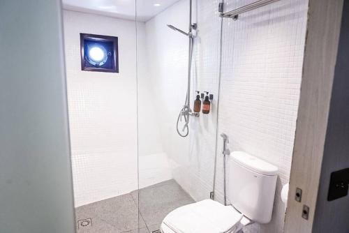 a bathroom with a toilet and a glass shower at Phinisi charter in Labuan Bajo in Labuan Bajo