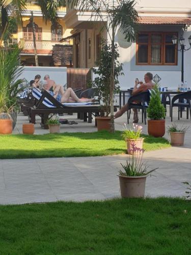a group of people sitting on benches in a park at Coastal Suites Apart Hotel ---- 8 minutes walk to beach in Benaulim