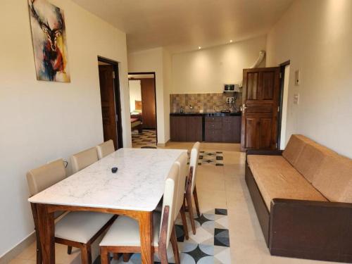 a living room with a table and a couch at Coastal Suites Apart Hotel ---- 8 minutes walk to beach in Benaulim