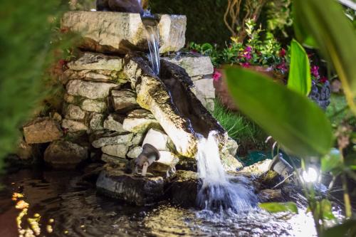 a waterfall in a pond in a garden at Antica Stazione in Chiaramonte Gulfi