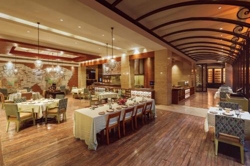 a restaurant with tables and chairs in a room at Hyatt Regency Pune Hotel & Residences in Pune