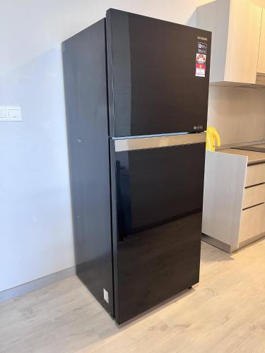 a black refrigerator sitting in the corner of a kitchen at Splendours Condos@Jesselton Quay in Kota Kinabalu