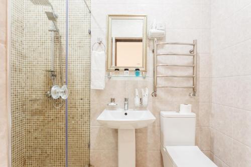 ein Bad mit einem Waschbecken, einem WC und einer Dusche in der Unterkunft Turkkurgan Hotel in Taschkent