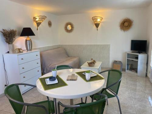 ein Wohnzimmer mit einem weißen Tisch und Stühlen in der Unterkunft Appartement T2 Olmeto in Olmeto