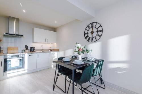 a kitchen with a table and chairs and a clock on the wall at Stunning Flat in Central Leeds by PureStay Short Stays in Leeds