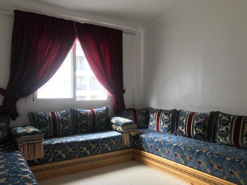 - un canapé dans le salon doté d'une fenêtre dans l'établissement Appartement Tanger diari, à Tanger