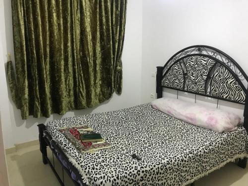 - une chambre avec un lit doté d'un couvre-lit noir et blanc dans l'établissement Appartement Tanger diari, à Tanger