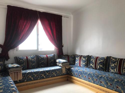 - un salon avec un canapé et une fenêtre dans l'établissement Appartement Tanger diari, à Tanger