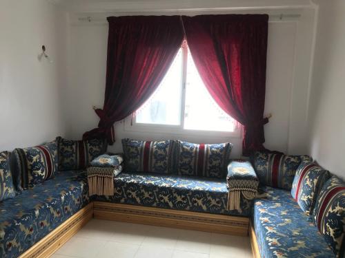 - un canapé dans le salon doté d'une fenêtre dans l'établissement Appartement Tanger diari, à Tanger