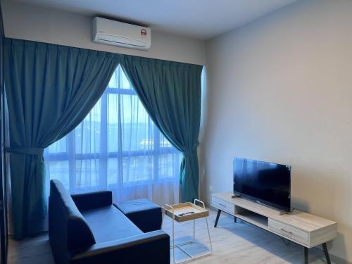 a living room with a large window with a couch and a television at Splendours Condos@Jesselton Quay in Kota Kinabalu
