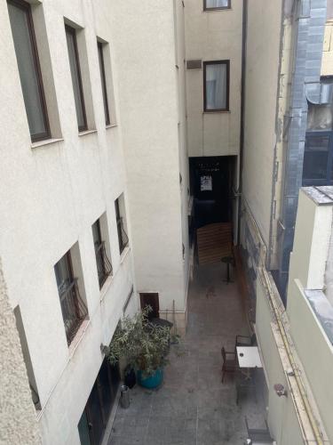 an alleyway between two buildings with plants and a bench at New Era Hotel Old Town Bucharest- parking with fee nearby - NOT at the hotel ! in Bucharest