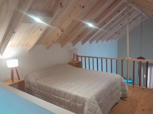 ein Schlafzimmer mit einem Bett in einem Zimmer mit Holzdecken in der Unterkunft Elegante cabaña. in El Calafate