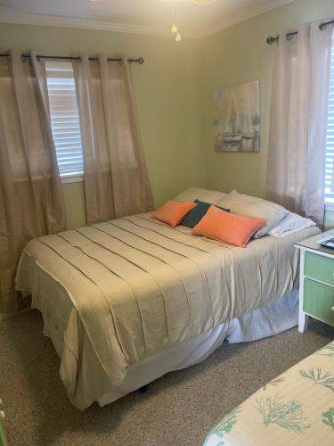 1 dormitorio con 2 camas con almohadas de color naranja en Bikini Bottom, en Carolina Beach