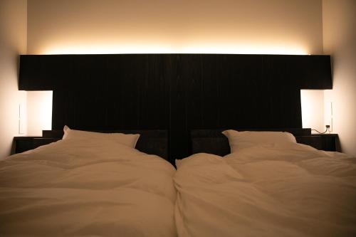 a bedroom with a large white bed with two pillows at オーベルジュ カラ 宗像 in Akama