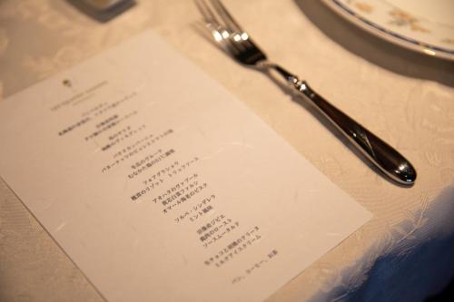 a menu on a table with a fork and knife at オーベルジュ カラ 宗像 in Akama