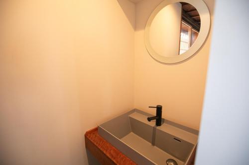 a bathroom with a sink and a mirror at オーベルジュ カラ 宗像 in Akama