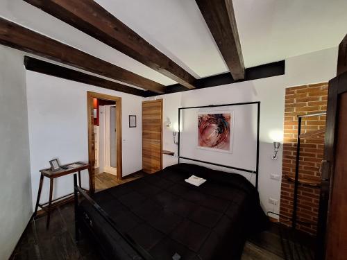 1 dormitorio con cama negra y pared de ladrillo en Morry's Lodge Guest House, en Sora