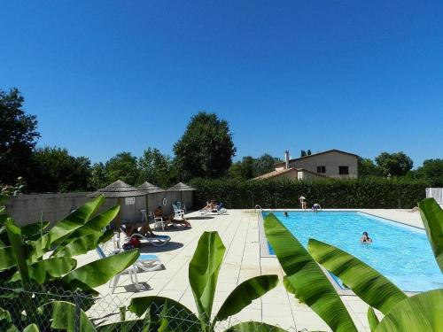 a large swimming pool with people sitting in chairs around it at camping Le Clos de la Lère in Cayriech