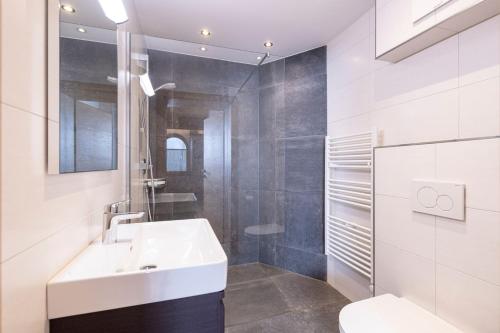 La salle de bains blanche est pourvue d'un lavabo et de toilettes. dans l'établissement Apart Stiegler, à Stumm
