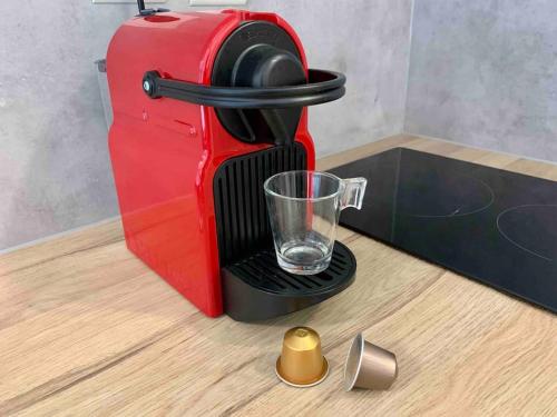 a red coffee maker with a glass on a table at Studio Le Pensier - Monplaisir in Lyon