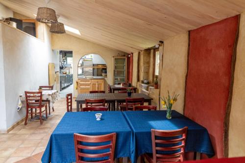 une salle à manger avec une table et des chaises bleues dans l'établissement Auberge de Lascours, gîte d'étape pleine nature., à Ceilhes-et-Rocozels