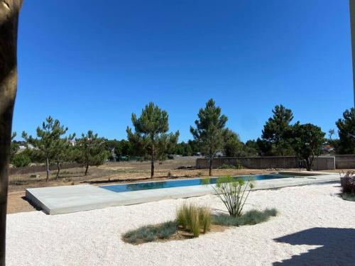 une piscine au milieu d'un champ arboré dans l'établissement Casa da Pergola - Beach Design Villa Private Pool, à Santo André