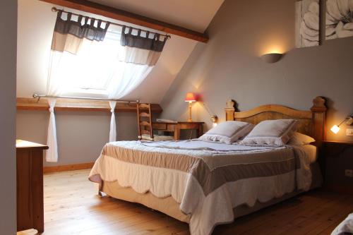 ein Schlafzimmer mit einem großen Bett und einem Fenster in der Unterkunft Gite 12 pers à 15kms de la plage in Plouégat-Moysan