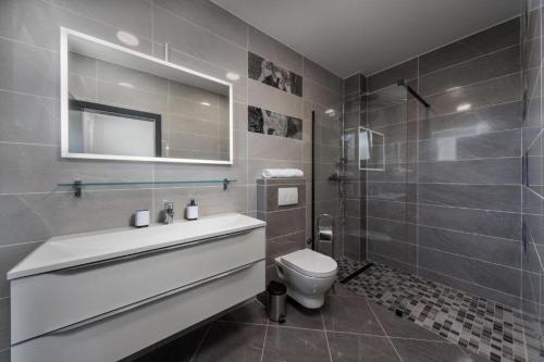 a bathroom with a sink and a toilet and a shower at Royal House 3 in Pašman