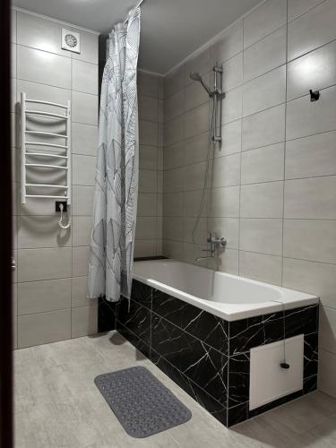 切爾諾夫策的住宿－Mayster Home，设有带浴缸和淋浴的浴室。