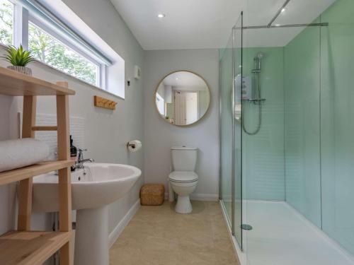 a bathroom with a sink toilet and a glass shower at 4 Bed in Holt 83070 in Sharrington
