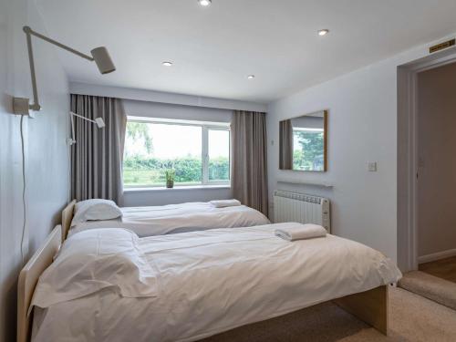 two beds in a bedroom with a window at 4 Bed in Holt 83070 in Sharrington