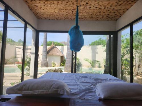 Ce lit se trouve dans un dortoir doté d'une grande fenêtre. dans l'établissement Tiny Villa Votre Villa Privatisée, à Ndangane