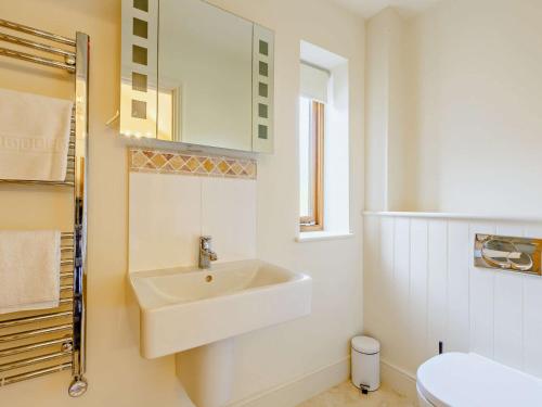 a white bathroom with a sink and a toilet at 3 Bed in Blakeney 83628 in Blakeney