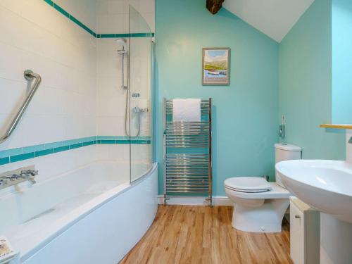 een badkamer met een bad, een toilet en een wastafel bij 3 Bed in Spark Bridge 83701 in Spark Bridge