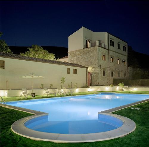 a large blue swimming pool in front of a building at Agriturismo Sant'Agata in Piana degli Albanesi
