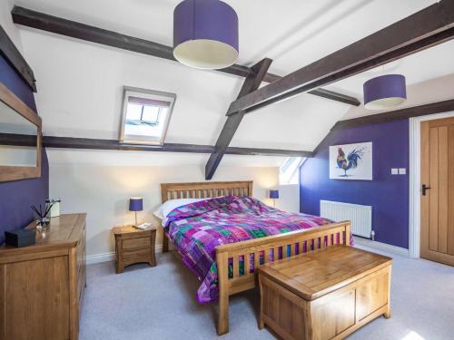 a bedroom with a king sized bed and purple walls at 4 Bed in Beadnell 83469 in Swinhoe