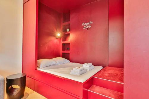 a room with a bed in a red wall at CMG Résidence Galeries Lafayette - Madeleine in Paris