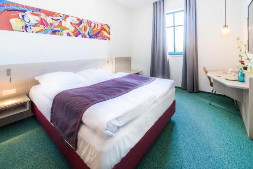 um quarto de hotel com uma cama grande e uma secretária em Hotel Cloppenburg em Cloppenburg