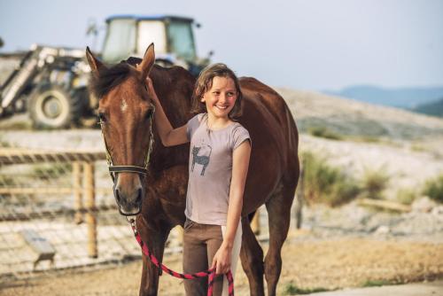 a young girl standing next to a brown horse at Glamping Diacceroni in Villamagna