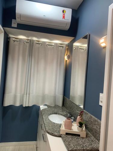 a bathroom with a white sink and a mirror at Ocean Flat Premium com vista para o mar in Vila Velha