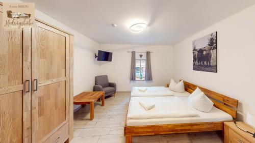 a room with two beds and a wooden door at Urlaub auf dem Bauernhof Hedwigshöhe in Hohnstein