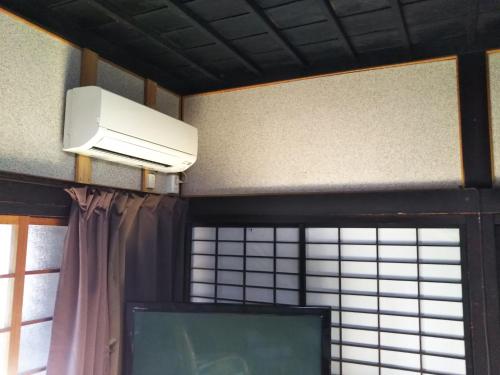 een woonkamer met een tv en airconditioning bij 御師の家　梅谷（UMEYA） in Fujikawaguchiko