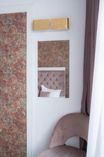 a room with a fireplace and a chair with a mirror at Hotel Marabella in Sibiu