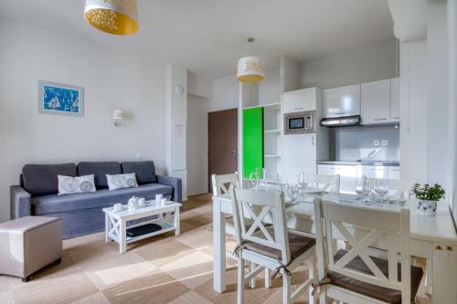 un salon avec une table et un canapé bleu dans l'établissement Kergonano - Parking privé et piscine, à Baden